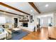 Spacious living room showcasing a white brick fireplace, hardwood floors, and exposed beams at 1305 Kimberly Dr, Raleigh, NC 27609
