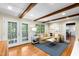 Bright living room featuring exposed wood beams, hardwood floors, and stylish french doors at 1305 Kimberly Dr, Raleigh, NC 27609