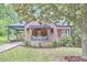 Charming brick house with mature landscaping, featuring a quaint front porch and inviting curb appeal at 1307 Arnette Ave, Durham, NC 27707