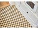 Close-up of a kitchen floor with a classic checkerboard pattern and white cabinetry at 1307 Arnette Ave, Durham, NC 27707