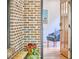 Foyer view of home with hardwood floors, brick accent wall, and chair with art in the background at 1307 Arnette Ave, Durham, NC 27707