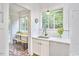 Bright kitchen area with sink, window, and view into an additional bright seating nook at 1307 Arnette Ave, Durham, NC 27707