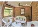 Covered porch with brick flooring and walls, offering a comfortable outdoor seating area at 1307 Arnette Ave, Durham, NC 27707