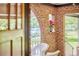 Charming brick porch with arched entryway, white wicker furniture, and a potted plant at 1307 Arnette Ave, Durham, NC 27707