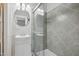Bathroom with gray tile, glass enclosed shower, sink and round mirror at 1331 Sunset Ave, Rocky Mount, NC 27804