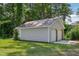 Detached two-car garage with white doors and siding, surrounded by lush greenery at 1331 Sunset Ave, Rocky Mount, NC 27804