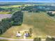 Sweeping aerial view showcases a home and barn surrounded by sprawling fields, forests, and picturesque landscapes at 1347 Crocker Rd, Smithfield, NC 27577