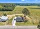 Aerial view featuring the home, the garage, and a wide field surrounded by trees and foliage at 1347 Crocker Rd, Smithfield, NC 27577