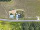 Bird's-eye view of a house and barn set against a landscape of fields and forest, highlighting the property's rural charm at 1347 Crocker Rd, Smithfield, NC 27577