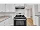 Stainless steel stove and hood complimented by granite countertops and wood-look floors in a bright kitchen at 1347 Crocker Rd, Smithfield, NC 27577