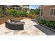 Outdoor patio with a circular seating arrangement and fire pit, surrounded by lush landscaping at 1437 Chelton Oaks Pl, Raleigh, NC 27614