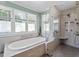 A pristine bathroom boasting a luxurious soaking tub, separate glass shower, and bright natural light from the large windows at 1437 Chelton Oaks Pl, Raleigh, NC 27614