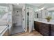 The renovated bathroom features a glass shower with bench, double vanity, and modern fixtures for a spa-like experience at 1437 Chelton Oaks Pl, Raleigh, NC 27614