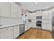 Bright kitchen features stainless steel appliances, white cabinets and hardwood flooring at 1437 Chelton Oaks Pl, Raleigh, NC 27614