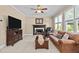 Cozy living room with a fireplace, plush sofa, television, and ceiling fan for a relaxing atmosphere at 1437 Chelton Oaks Pl, Raleigh, NC 27614