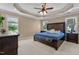This main bedroom offers a tray ceiling, large bed with beautiful pillows, and lots of natural light from the large windows at 1437 Chelton Oaks Pl, Raleigh, NC 27614