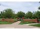 Inviting brick entrance to Oakboro Park with lush landscaping and a paved pathway at 1437 Chelton Oaks Pl, Raleigh, NC 27614