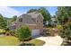 Exterior view featuring a side-entry garage, well-maintained lawn, and neatly landscaped surroundings at 1437 Chelton Oaks Pl, Raleigh, NC 27614