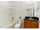 Bright bathroom featuring a sleek vanity with granite counters and a shower-tub combo at 1522 Palmer Hill Dr, Durham, NC 27703