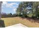 Large backyard with a mix of grass and pine straw, bordered by a wood fence and mature trees at 163 Davelyn Ct, Garner, NC 27529