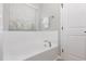 Bright white bathroom features a soaking tub with a window view and a convenient towel rack for added comfort at 163 Davelyn Ct, Garner, NC 27529