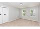Bright bedroom with carpet, two windows offering views, and a spacious closet, creating a functional space at 163 Davelyn Ct, Garner, NC 27529