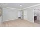 Spacious bedroom with neutral carpet, crown molding and multiple doors leading to different areas of the home at 163 Davelyn Ct, Garner, NC 27529