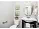 Stylish powder room with an oval mirror, a dark vanity, and floral artwork adding a touch of elegance at 163 Davelyn Ct, Garner, NC 27529