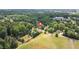 Expansive aerial shot of a home nestled among lush greenery and an open field at 1647 Turner Rd, Mebane, NC 27302