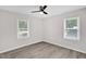 Bedroom with light gray walls, vinyl floors, ceiling fan and two windows at 1647 Turner Rd, Mebane, NC 27302