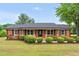 Charming brick home with a covered front porch and mature landscaping at 1647 Turner Rd, Mebane, NC 27302