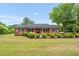Charming brick home with a covered front porch and mature landscaping at 1647 Turner Rd, Mebane, NC 27302