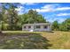Charming white home featuring a brick facade, decorative shutters, manicured landscaping, and inviting front porch at 1732 Green Pace Rd, Zebulon, NC 27597