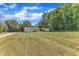 A charming single-story home features a well-maintained lawn, detached garage, and classic architecture under a blue sky at 1732 Green Pace Rd, Zebulon, NC 27597