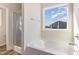 A bathroom features a tub, glass shower, and a window with lots of natural light at 175 Trescott St, Smithfield, NC 27577