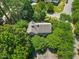 Aerial view of a house surrounded by lush greenery and mature trees in a peaceful neighborhood at 1806 Carrington Dr, Raleigh, NC 27615