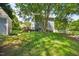 View of backyard showing a well-maintained lawn, deck, outbuilding and privacy fence at 1806 Carrington Dr, Raleigh, NC 27615