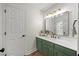 Stylish bathroom featuring a large mirror, modern lighting fixtures, and a vibrant green vanity at 1806 Carrington Dr, Raleigh, NC 27615