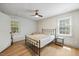 Cozy bedroom with a ceiling fan, wood floors, and bright natural light streaming through the windows at 1806 Carrington Dr, Raleigh, NC 27615