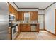 Well-lit kitchen with stainless steel appliances, wood cabinets, and wood-style flooring at 1806 Carrington Dr, Raleigh, NC 27615