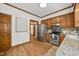 Well-lit kitchen featuring stainless steel appliances, wooden cabinets, and granite countertops at 1806 Carrington Dr, Raleigh, NC 27615