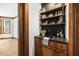 Stylish wet bar featuring wood cabinets, open shelving, dark countertops, and views to the breakfast area at 1806 Carrington Dr, Raleigh, NC 27615