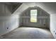 View of the attic featuring an angular ceiling, window and unfinished walls at 196 Cozy Brook Ct, Clayton, NC 27520