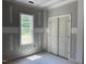 Bedroom view showcasing a window with natural light and closet doors at 196 Cozy Brook Ct, Clayton, NC 27520