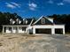 Charming new construction featuring a three-car garage and dormer windows under a blue sky at 196 Cozy Brook Ct, Clayton, NC 27520