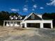 New construction showcasing a three-car garage and dormer windows, offering ample parking and natural light at 196 Cozy Brook Ct, Clayton, NC 27520
