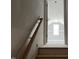 Staircase with wooden handrail and view into an upstairs bedroom with a window at 196 Cozy Brook Ct, Clayton, NC 27520
