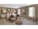 Serene main bedroom with neutral decor, comfortable seating area, and ample natural light from two large windows at 196 Ethel Ln, Angier, NC 27501