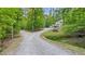 Driveway leading to the house with lush greenery and mature trees surrounding the home at 196 Tara Ln, Timberlake, NC 27583