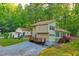 View of house and outbuilding surrounded by lush greenery and trees at 196 Tara Ln, Timberlake, NC 27583